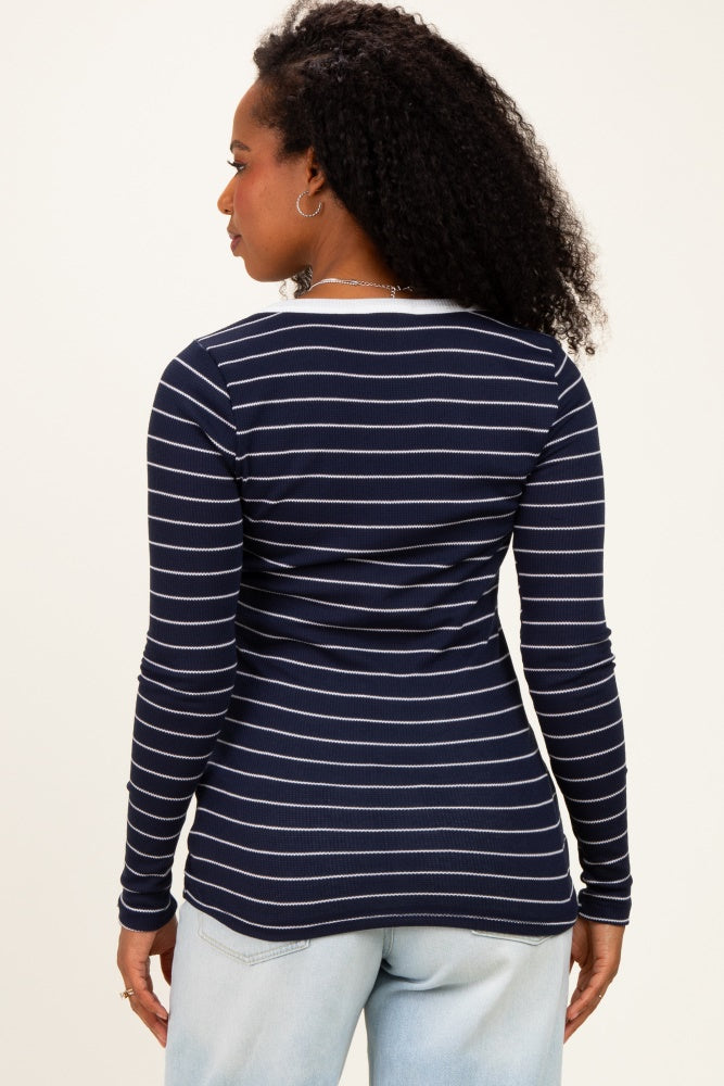 woman wearing a navy blue long sleeve striped top with a fitted silhouette and round neckline viewed from the back
