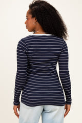 woman wearing a navy blue long sleeve striped top with a fitted silhouette and round neckline viewed from the back