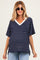 woman wearing a navy and white striped maternity top with a v-neck and pocket, styled with sunglasses and relaxed jeans