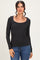 woman wearing a black long sleeve fitted top with a scoop neckline and textured fabric