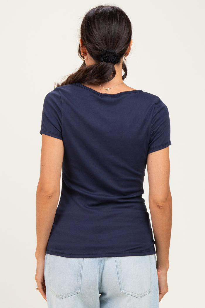 woman wearing a navy blue short sleeve top with a fitted silhouette and scoop neck, viewed from the back