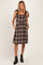 woman wearing a brown plaid maternity dress with tie straps and side pockets