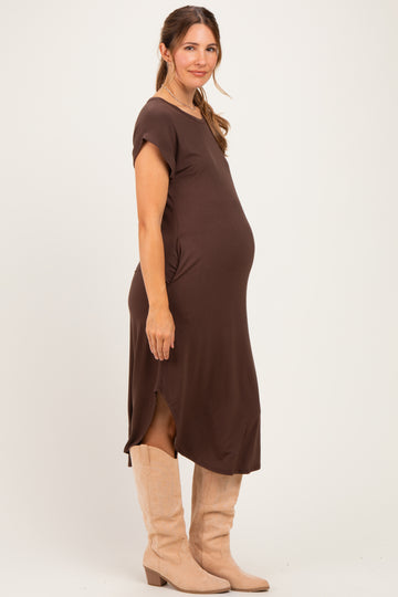 woman wearing a brown short sleeve maternity dress with side slits and a visible baby bump