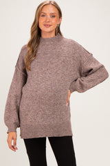 woman wearing a mauve oversized maternity sweater with a high neck and balloon sleeves