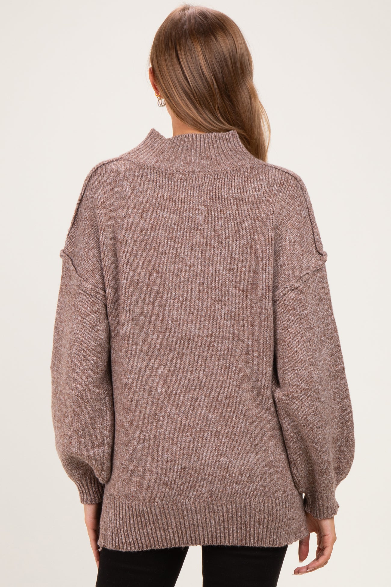 woman wearing a cozy brown maternity sweater with a high neck and balloon sleeves, showing a relaxed fit from the back