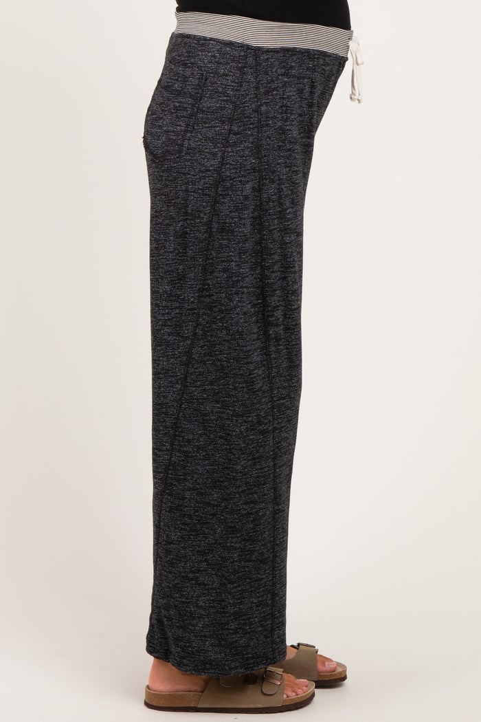 woman wearing dark gray maternity lounge pants with a drawstring waist, showing her baby bump on the side