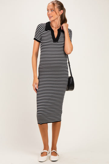 woman wearing a black and white striped maternity dress with short sleeves and a v-neck, holding a black bag