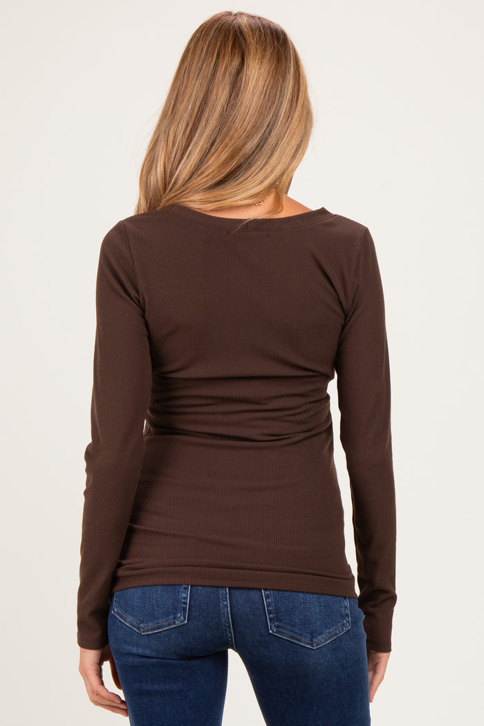 woman wearing a brown maternity top with a fitted silhouette and long sleeves, seen from the back