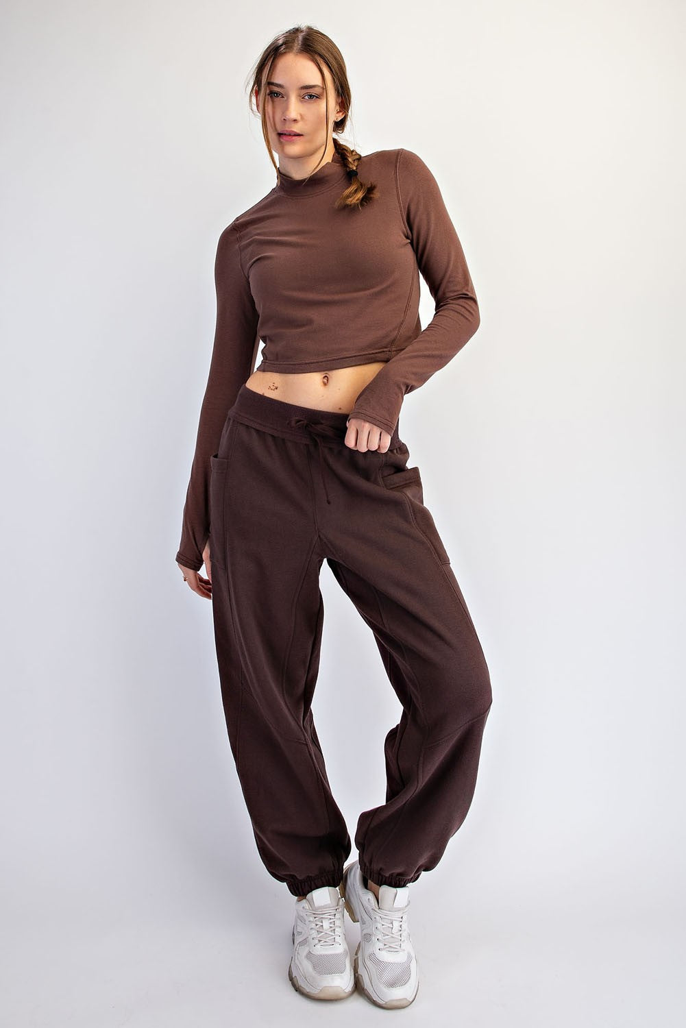 woman wearing a brown cropped long sleeve top and matching baggy sweatpants with elastic cuffs