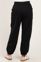 woman wearing black jogger pants with elastic cuffs and side pockets, styled with white sneakers