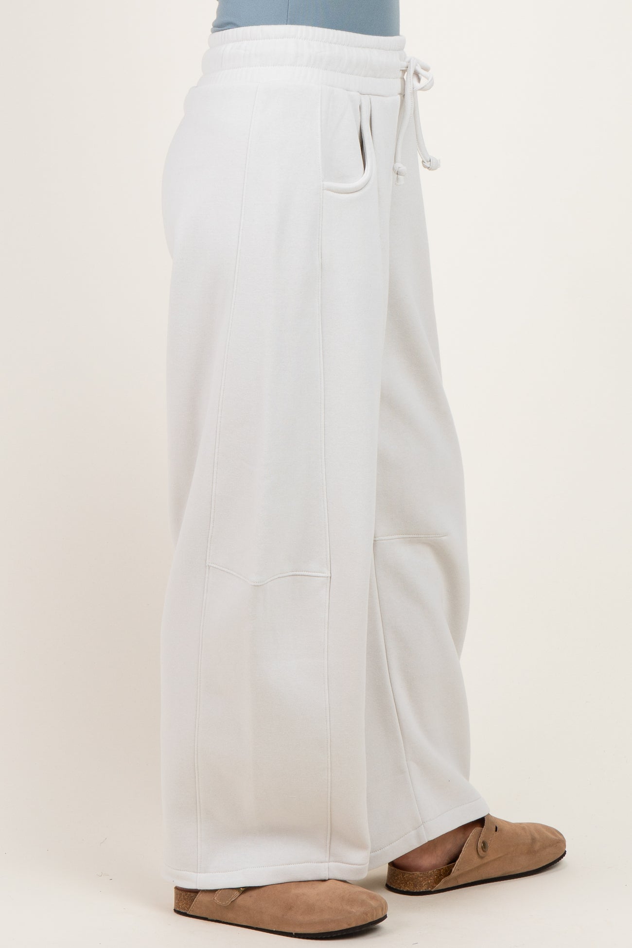 woman wearing white wide-leg sweatpants with pockets and a drawstring waistband