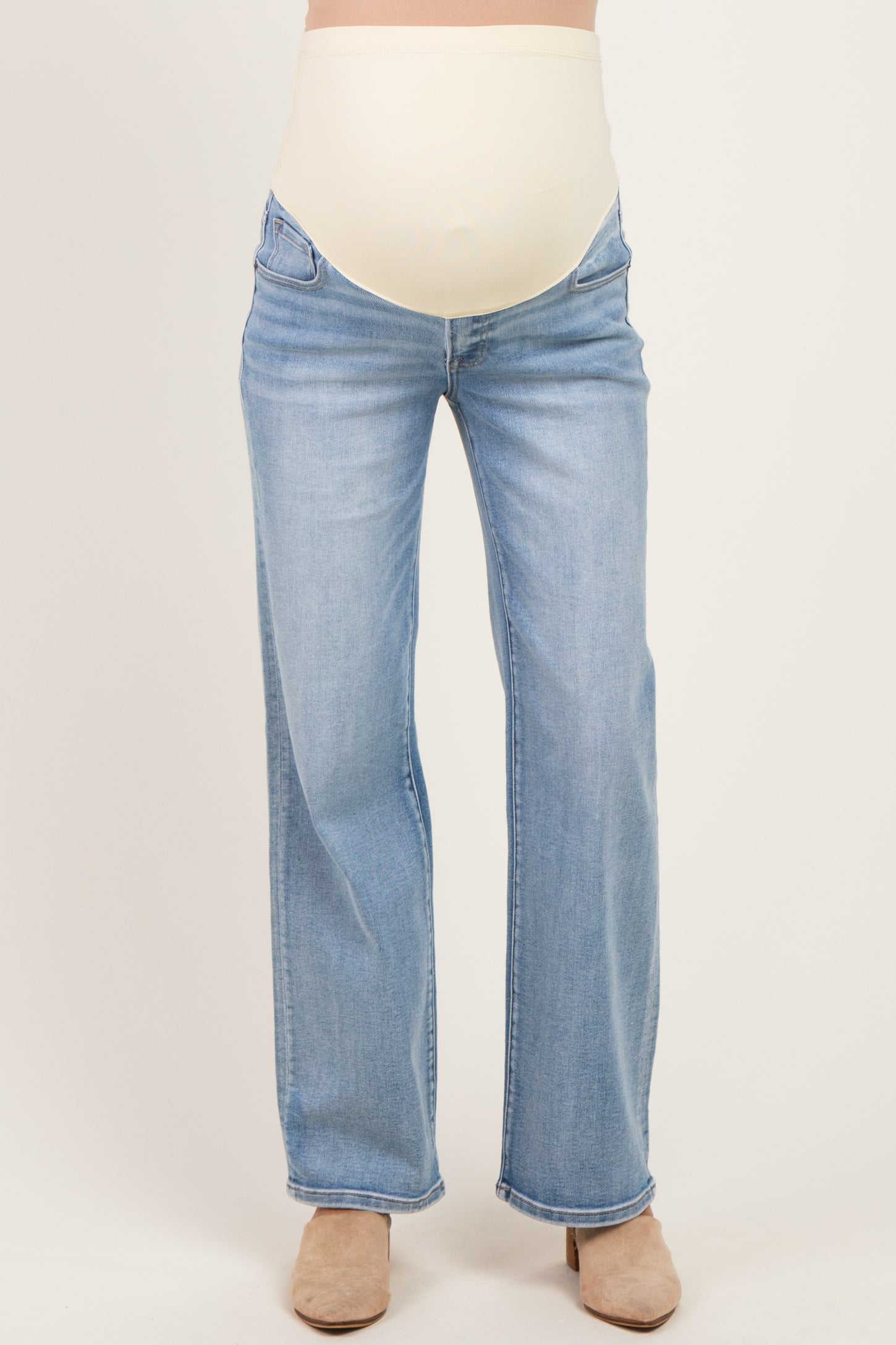 woman wearing light blue maternity jeans with a beige over-the-belly panel