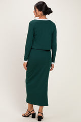 woman wearing a green ribbed two-piece dress with a cropped top and long skirt, showing the back view
