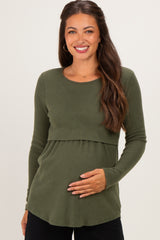 woman wearing an olive green long sleeve ribbed maternity top and holding her baby bump