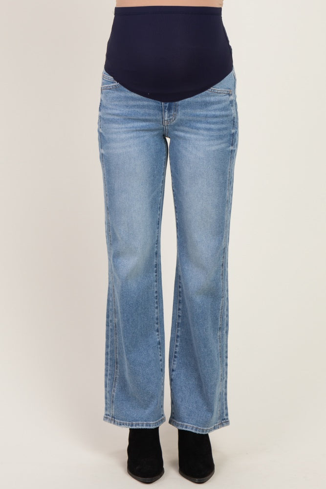 woman wearing light wash flared maternity jeans with a navy blue over-the-bump panel