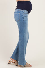 woman wearing light blue maternity flared jeans with a dark blue stretch panel and a visible baby bump