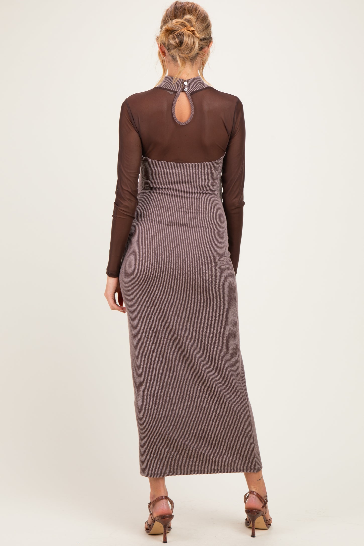 woman wearing a brown striped maternity maxi dress with long sleeves and a keyhole back detail