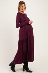 woman wearing a long sleeve maternity dress in deep burgundy with tiered skirt and baby bump visible