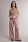 woman wearing a tan sleeveless cardigan and pink ribbed wide-leg pants
