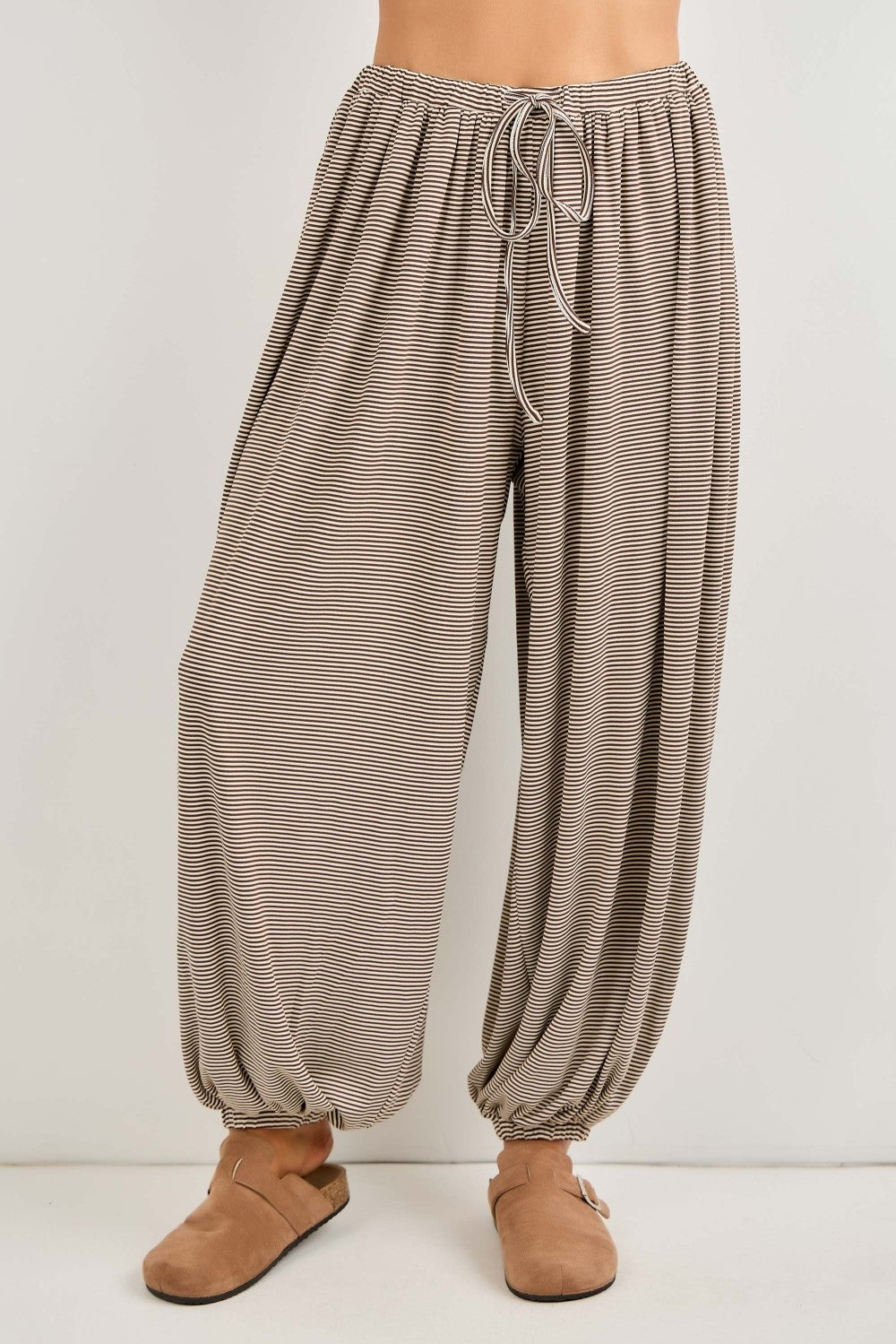 woman wearing light brown striped wide-leg pants with an elastic waistband and adjustable drawstring