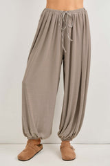 woman wearing light brown striped wide-leg pants with an elastic waistband and adjustable drawstring