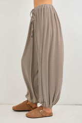 woman wearing beige striped wide-leg pants with an elastic waistband and gathered cuffs