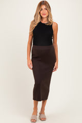 woman wearing a black sleeveless top and a brown ribbed midi maternity skirt