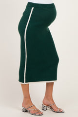 woman wearing a green maternity skirt with a white side stripe and a visible baby bump