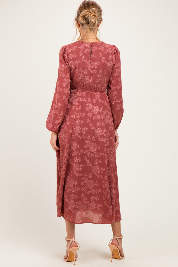 woman wearing a rust floral long sleeve maternity dress with a flowing silhouette and back button detail