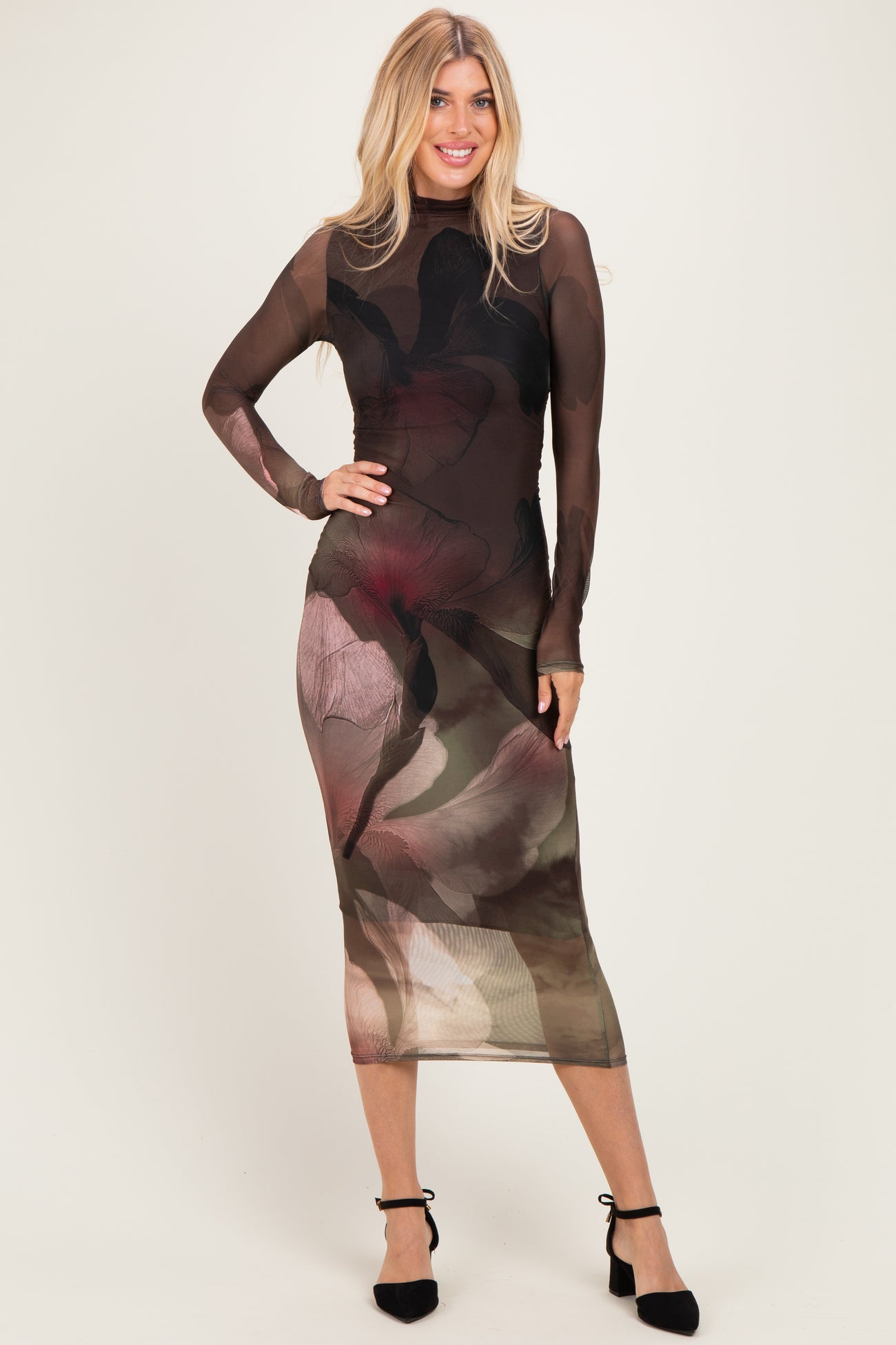 woman wearing a long sleeve sheer floral mesh midi dress with a fitted silhouette and black strappy heels