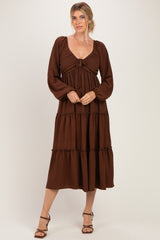 woman wearing a brown tiered midi dress with puff sleeves and a tie front detail