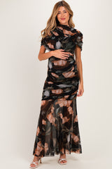 woman wearing a black floral maternity gown with short sleeves and a fitted bodice, holding her baby bump