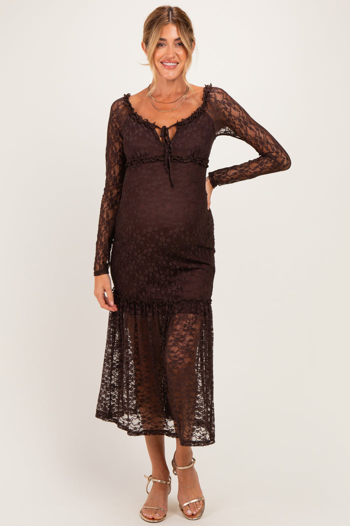 woman wearing a brown lace maternity dress with long sleeves and a tie front detail, showcasing her baby bump