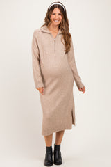 woman wearing a beige zip-up maternity sweater dress with side slits and a baby bump visible