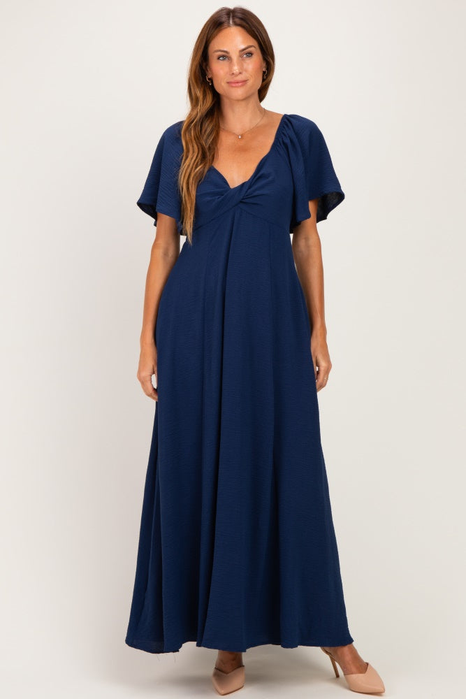 woman wearing a navy blue maxi dress with short flutter sleeves and a fitted bodice