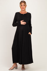 woman wearing a black long sleeve maternity maxi dress with a baby bump and pockets