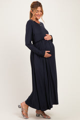 woman wearing a navy blue long sleeve maternity dress and holding her baby bump
