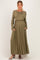 woman wearing an olive green long sleeve maternity dress with a cinched waist and pockets, revealing a baby bump