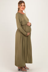 woman wearing an olive green long sleeve maternity dress with an elastic waist and visible baby bump