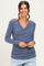 woman wearing a slate blue long sleeve wrap top with gathered side details and a deep V-neck