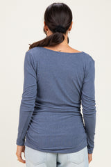 woman wearing a dark blue long sleeve ribbed top with a relaxed fit, seen from the back