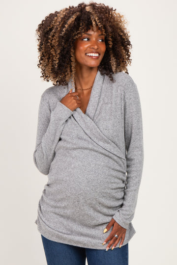 woman wearing a gray wrap maternity top with ruching detailing and a visible baby bump, styled casually with jeans