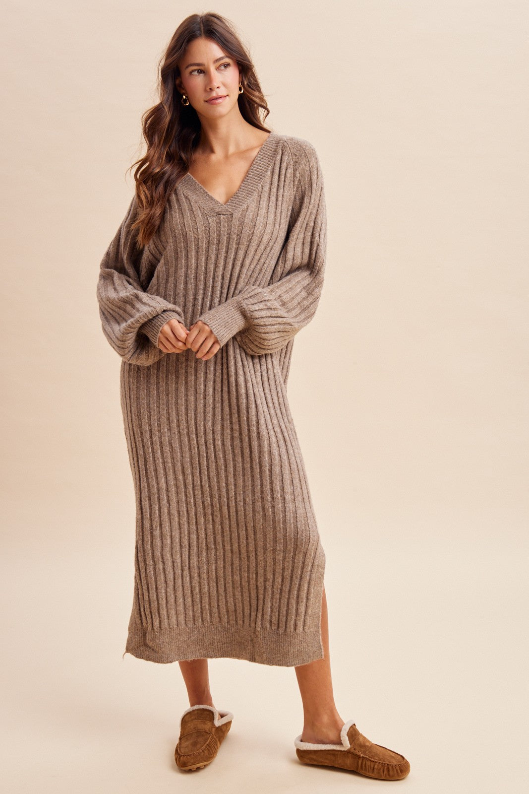 woman wearing a tan ribbed knitted long sleeve sweater dress and brown slippers