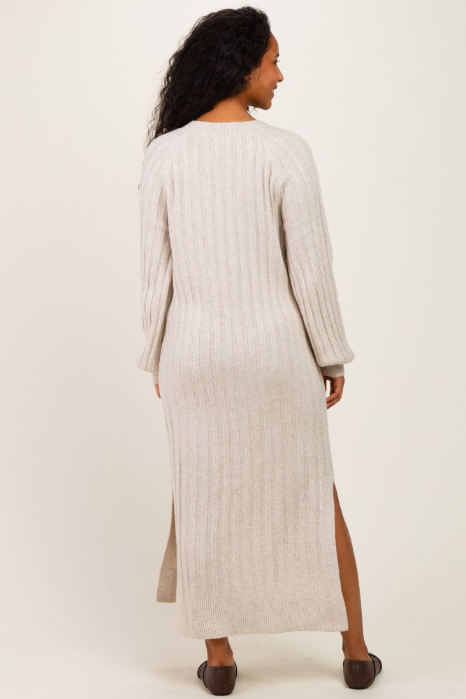 woman wearing a light beige ribbed maternity sweater dress with side slits and long sleeves, showing her baby bump