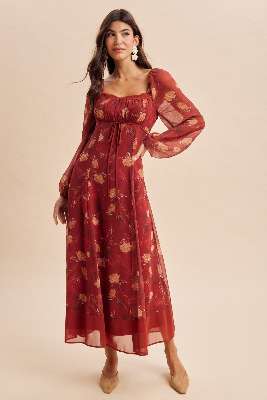 woman wearing a burgundy long sleeve floral maxi dress with a square neckline and gathered detail at the waist