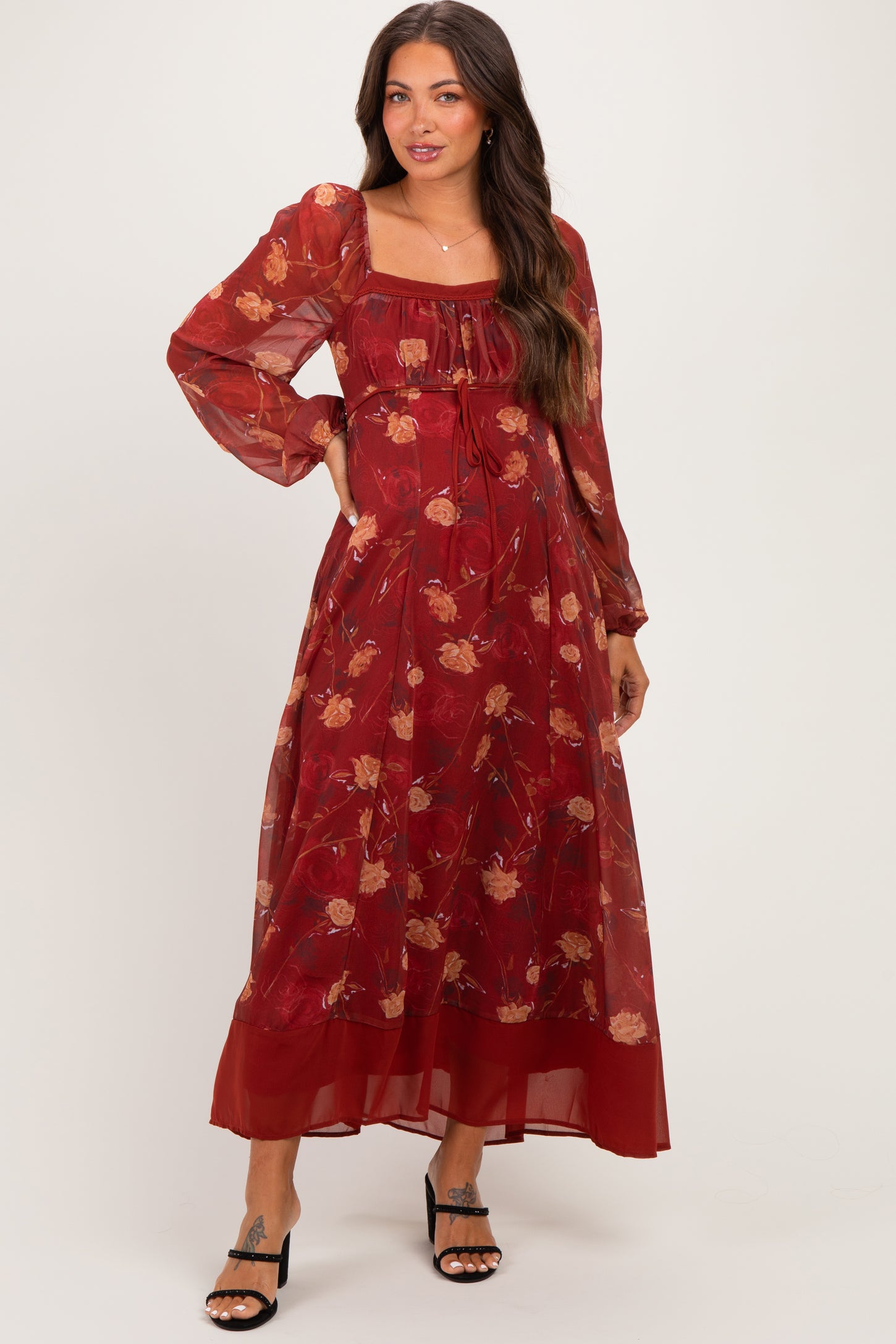 woman wearing a red floral maternity dress with long sleeves and a square neckline
