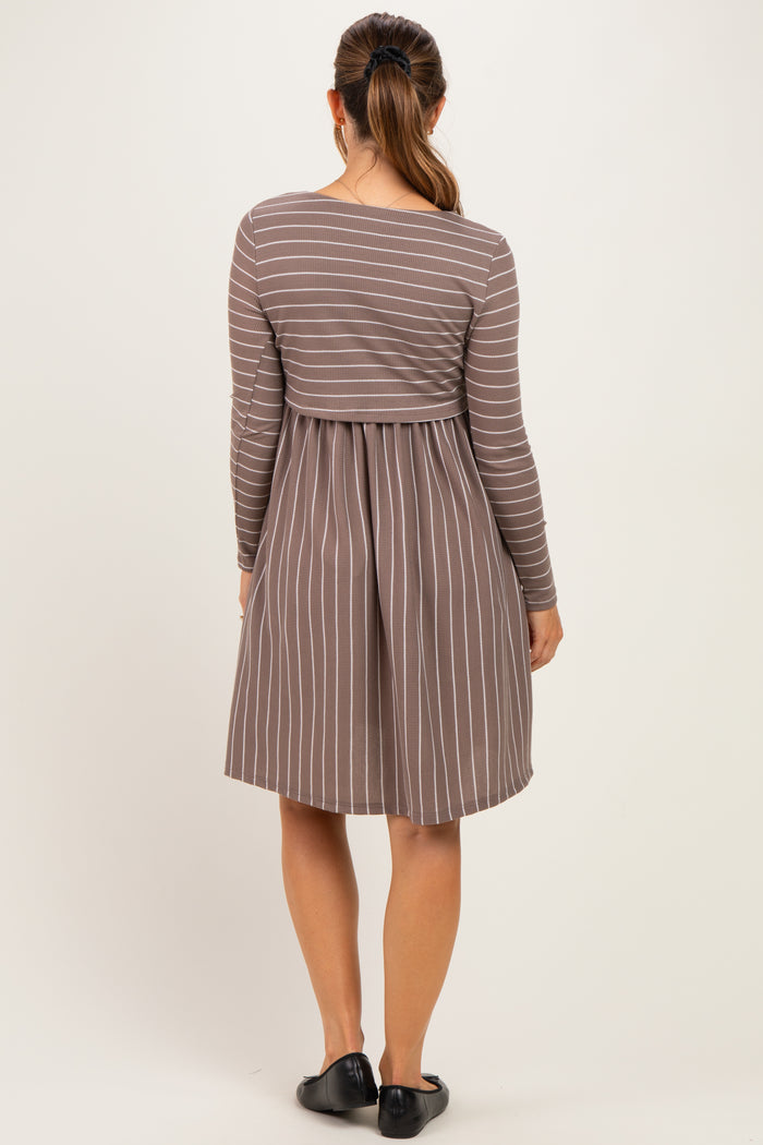 woman wearing a brown striped maternity dress with long sleeves and a fitted bodice, showing a baby bump from the back