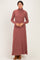 woman wearing a rust long sleeve turtleneck maxi dress with a ribbed texture and brown heeled shoes