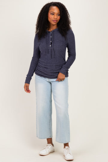 woman wearing a navy blue long sleeve henley top with buttons and light wash cropped jeans