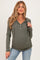 woman wearing a dark green maternity hoodie with a buttoned neckline and ruching at the sides, showcasing her baby bump